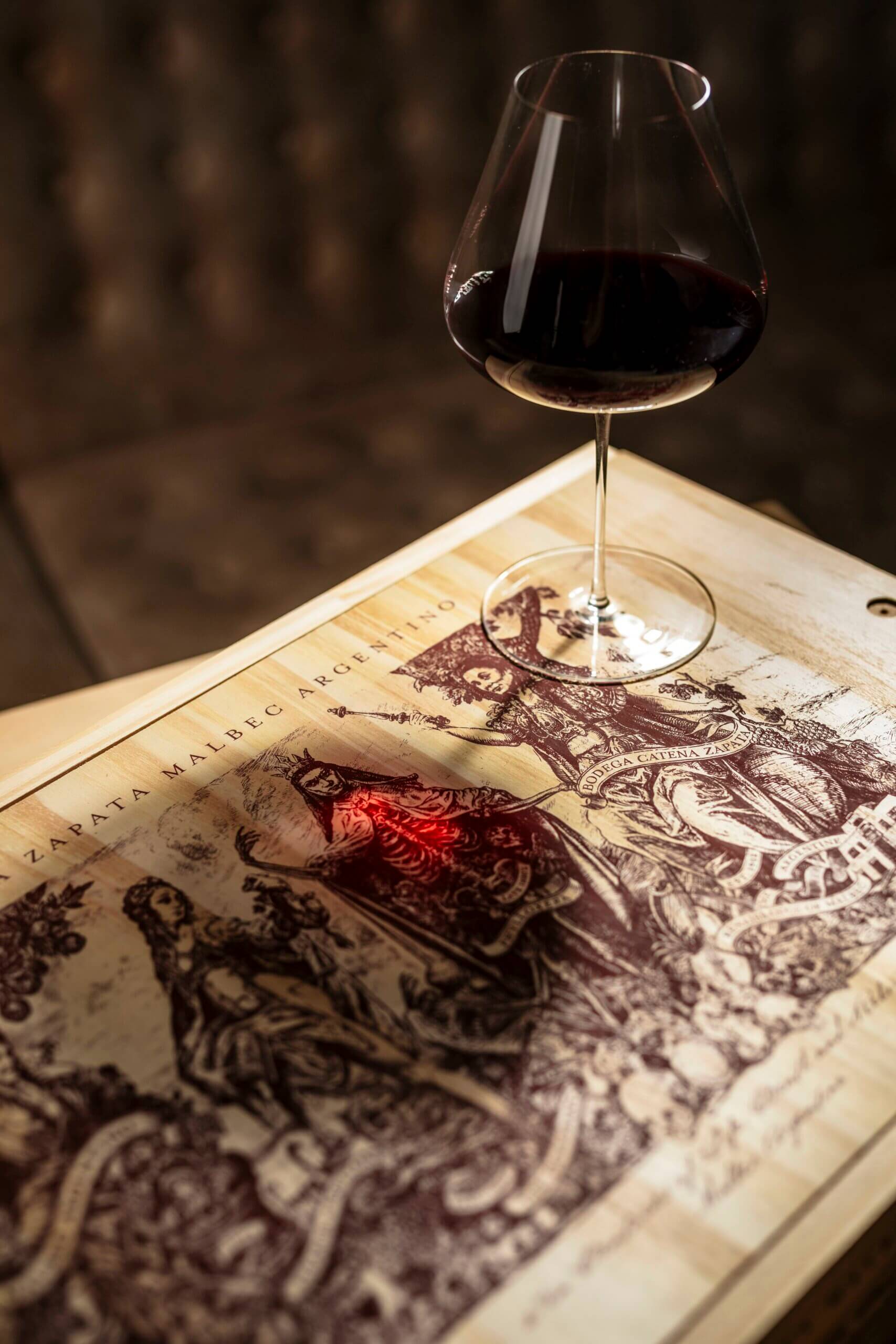 Catena Zapata 酒箱上盛在勃艮第杯中的红酒